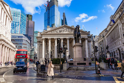 People walking on street amidst buildings in city