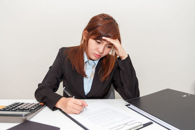 Young woman using mobile phone while sitting on table