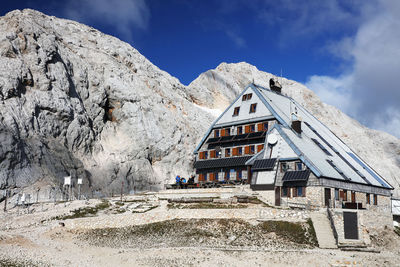 Low angle view of houses on mountain against sky