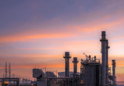 Factory against sky during sunset