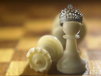 Close-up of crown on pawn at chess board