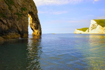 Rock formation in sea against sky