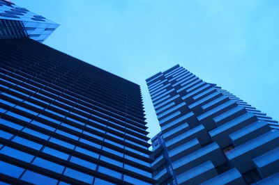 Low angle view of skyscrapers against clear blue sky