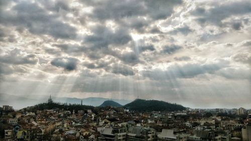 View of cityscape against cloudy sky