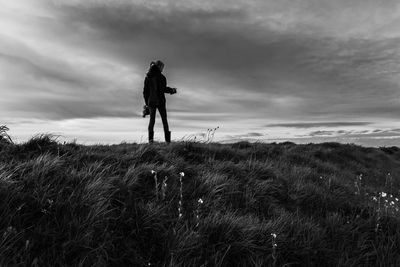 Full length of man with arms raised against sky