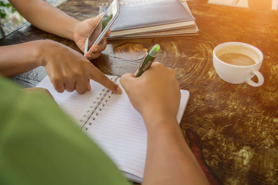 Midsection of woman holding book on table