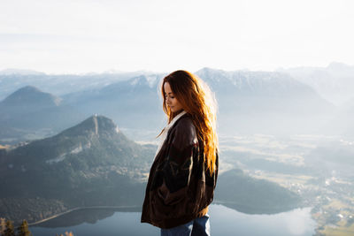 Woman standing on mountain against sky