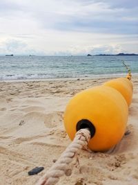 Close-up of yellow water on beach against sky