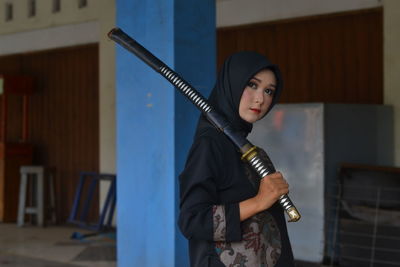 Portrait of young woman holding sword