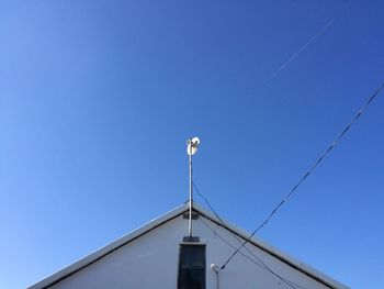 Low angle view of power lines against clear blue sky