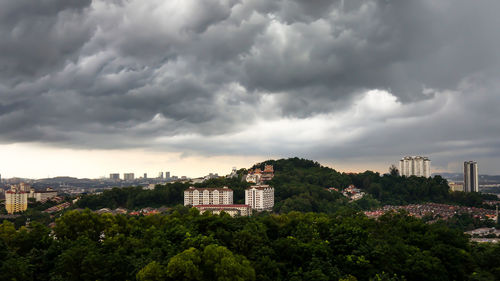 Buildings in city against cloudy sky