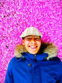 Portrait of smiling young man against pink petals