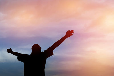 Low angle view of silhouette hand against sky during sunset