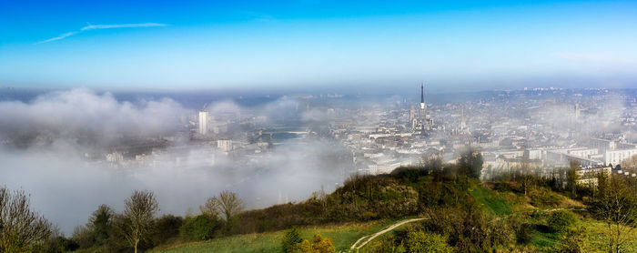 Panoramic view of trees and cityscape against sky