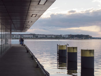 People by sea against sky