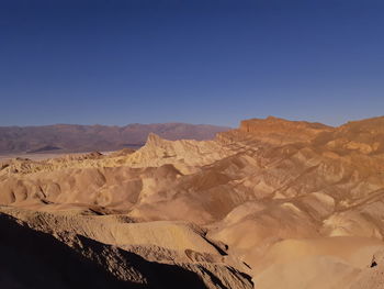 Scenic view of dramatic landscape against clear blue sky