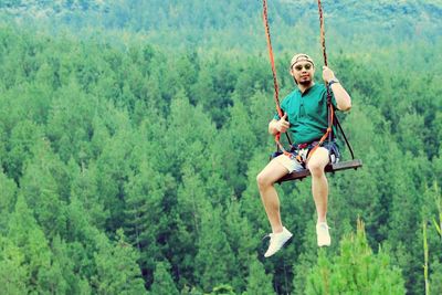 Full length of woman on rope in forest