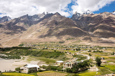 Scenic view of houses and mountains against sky