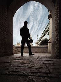 Full length of silhouette man standing at archway