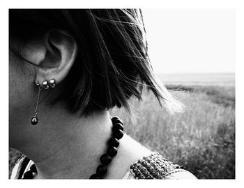 Close-up of woman wearing earrings against sky