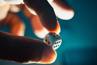 Close-up of person holding a dice at night