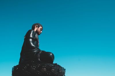 Low angle view of statue against blue sky