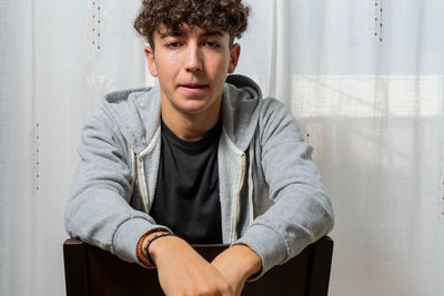 Portrait of young man sitting on table