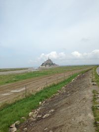 Dirt road passing through field