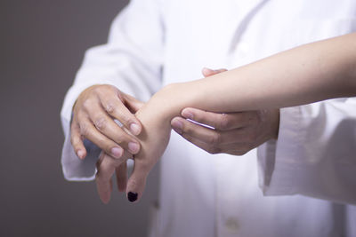 Midsection of doctor examining hand