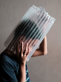 A boy head stuck in plastic wrapper