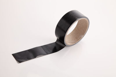 Close-up of black adhesive tape over white background