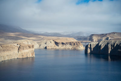 Scenic view of lake by mountain against sky