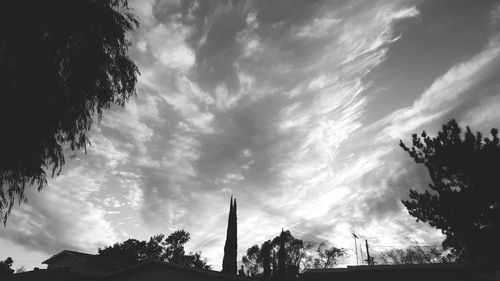 Low angle view of silhouette trees against cloudy sky