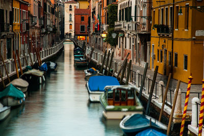 Boats in canal amidst buildings in city