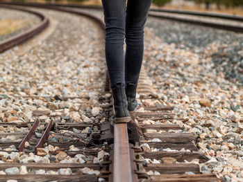 Low section of woman standing on railroad track