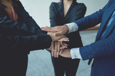 Midsection of business people stacking hands