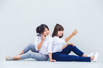 Friends sitting against white background