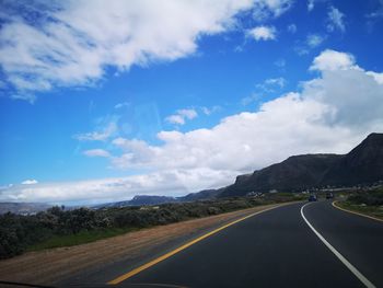 Empty road along landscape against sky