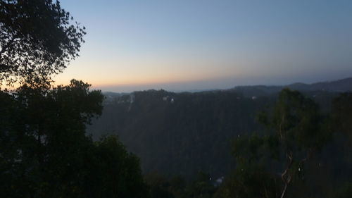 Scenic view of silhouette trees against sky at sunset