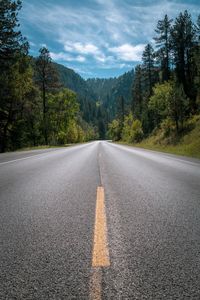 Road leading towards mountain against sky