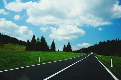 Country road passing through grassy field