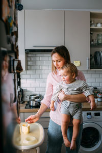 Mom feeds a small child at home with yogurt from a spoon. family concept