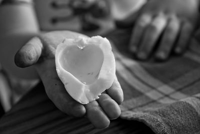 Close-up of hand holding heart shape egg piece