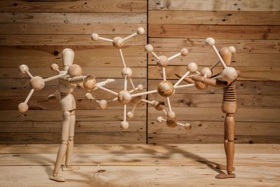 Close-up of wooden figurines holding molecular structure