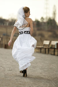 Young woman with umbrella walking on land