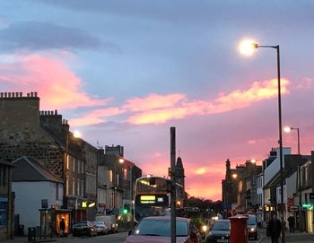 Cars on city street at dusk