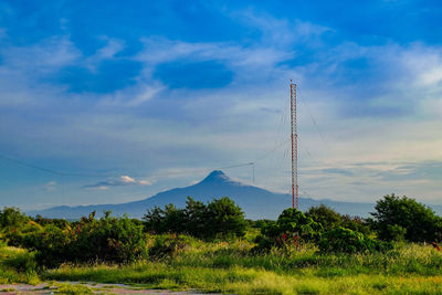 Electricity pylon on field against sky