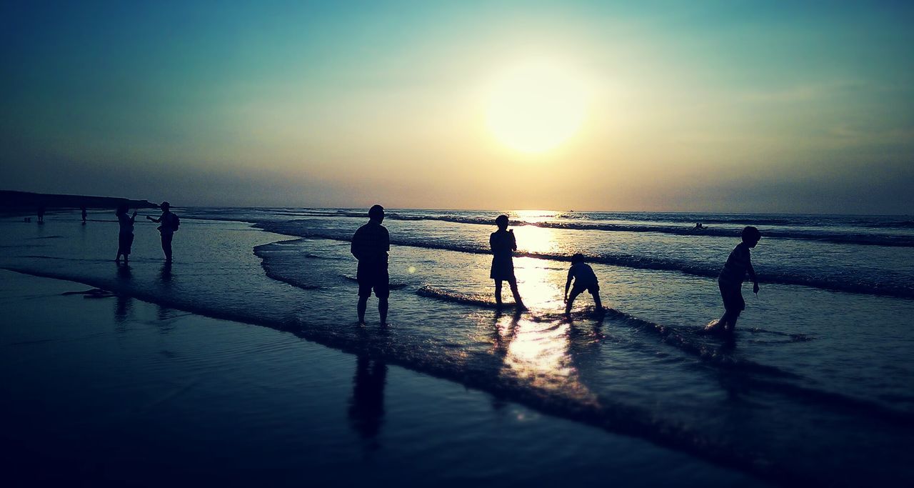 water, sea, sunset, horizon over water, sun, beach, reflection, silhouette, scenics, sky, tranquil scene, shore, beauty in nature, tranquility, nature, sunlight, idyllic, medium group of people, pier