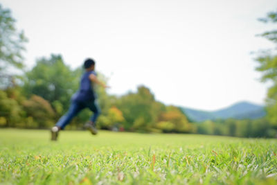 Side view of a boy running on field