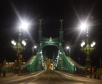 Illuminated bridge against sky at dusk